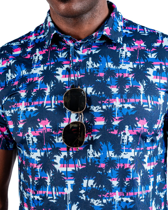 Men’s Palm Drip Dawn golf polo by Pins & Aces featuring navy palm trees over a blue, pink, and white tropical print with short sleeves and an athletic performance fit.