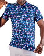 Men’s Palm Drip Dawn golf polo by Pins & Aces featuring navy palm trees over a blue, pink, and white tropical print with short sleeves and an athletic performance fit.
