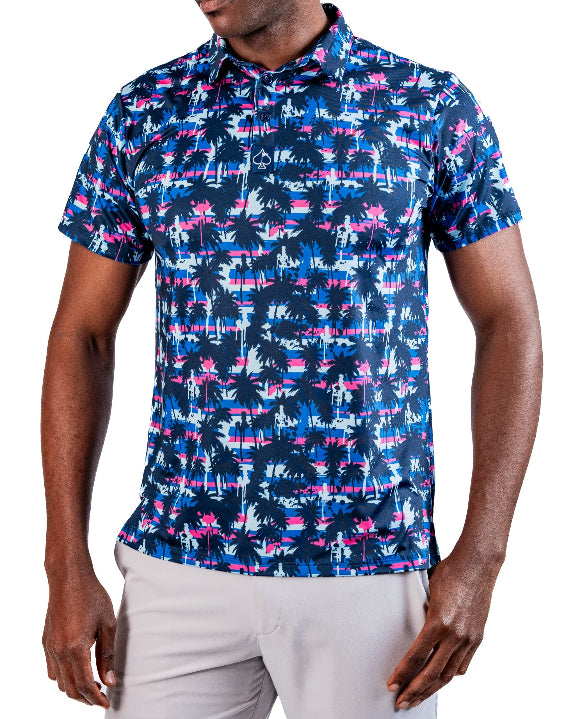Men’s Palm Drip Dawn golf polo by Pins & Aces featuring navy palm trees over a blue, pink, and white tropical print with short sleeves and an athletic performance fit.