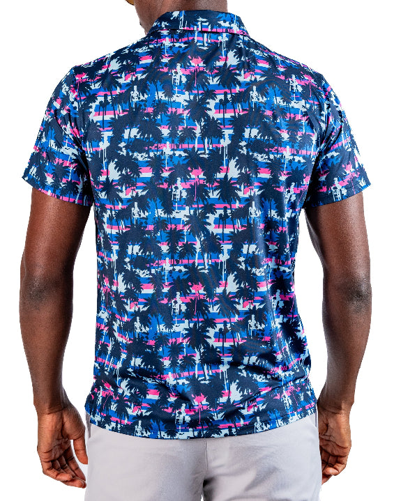 Men’s Palm Drip Dawn golf polo by Pins & Aces featuring navy palm trees over a blue, pink, and white tropical print with short sleeves and an athletic performance fit.
