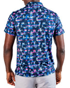 Men’s Palm Drip Dawn golf polo by Pins & Aces featuring navy palm trees over a blue, pink, and white tropical print with short sleeves and an athletic performance fit.