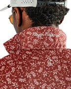 Men’s Autumn Bloom golf polo by Pins & Aces featuring a rust-colored all-over cream floral print, short sleeves, blade collar, and athletic performance fit.