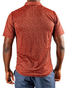 Men’s Filament golf polo by Pins & Aces featuring a rust and burnt orange abstract line pattern, short sleeves, modern blade collar, and athletic performance fit.