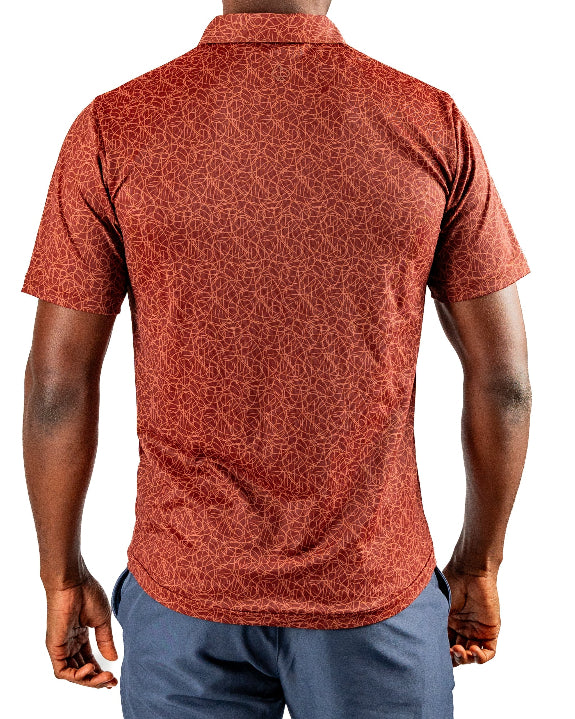 Men’s Filament golf polo by Pins & Aces featuring a rust and burnt orange abstract line pattern, short sleeves, modern blade collar, and athletic performance fit.