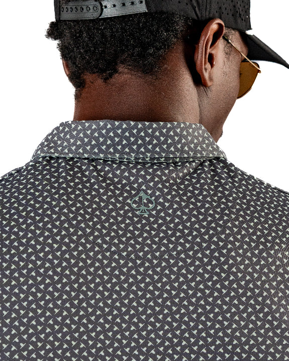 Men’s Jade Drops golf polo by Pins & Aces featuring a dark jade green geometric pattern, modern blade collar, short sleeves, and athletic performance fit.