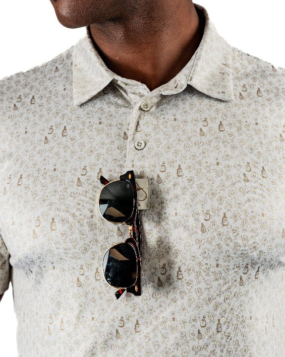 Men’s Drinking Buddies golf polo by Pins & Aces featuring a subtle drinking-inspired all-over print on a cream short-sleeve performance polo with an athletic fit.