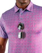 Men’s Sugar Circuit golf polo by Pins & Aces featuring a vibrant pink, purple, and blue geometric all-over pattern with short sleeves and an athletic performance fit.