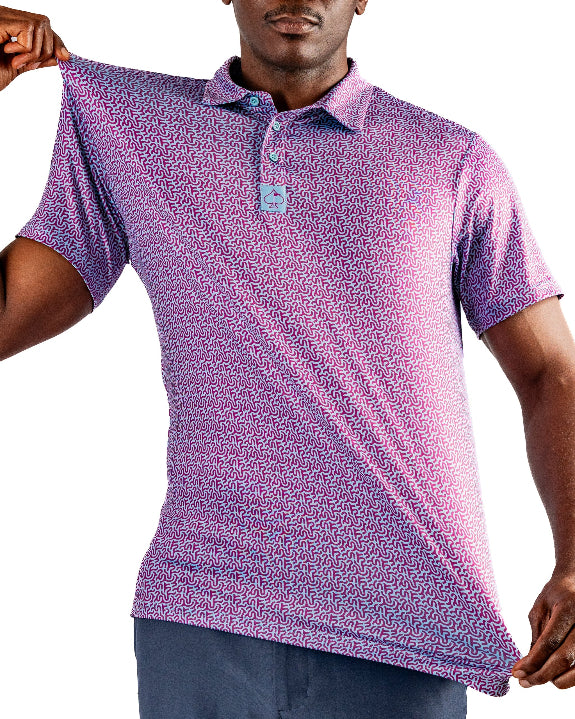 Men’s Sugar Circuit golf polo by Pins & Aces featuring a vibrant pink, purple, and blue geometric all-over pattern with short sleeves and an athletic performance fit.