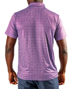 Men’s Sugar Circuit golf polo by Pins & Aces featuring a vibrant pink, purple, and blue geometric all-over pattern with short sleeves and an athletic performance fit.