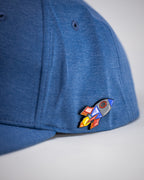Blue Performance Spade golf hat by Pins & Aces featuring an embroidered Fairway Wave Spade logo, adjustable snapback, curved bill, and built-in magnetic golf ball marker holder.