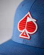 Blue Performance Spade golf hat by Pins & Aces featuring an embroidered Fairway Wave Spade logo, adjustable snapback, curved bill, and built-in magnetic golf ball marker holder.
