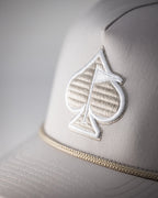 Bone off-white perforated rope golf hat by Pins & Aces featuring breathable perforated panels, braided rope detail, adjustable snapback, and built-in magnetic golf ball marker holder.