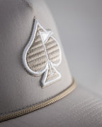 Bone off-white perforated rope golf hat by Pins & Aces featuring breathable perforated panels, braided rope detail, adjustable snapback, and built-in magnetic golf ball marker holder.