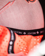 Highlighter pink perforated rope golf hat by Pins & Aces featuring an embroidered Fairway Wave Spade logo, adjustable snapback, and built-in magnetic golf ball marker holder.