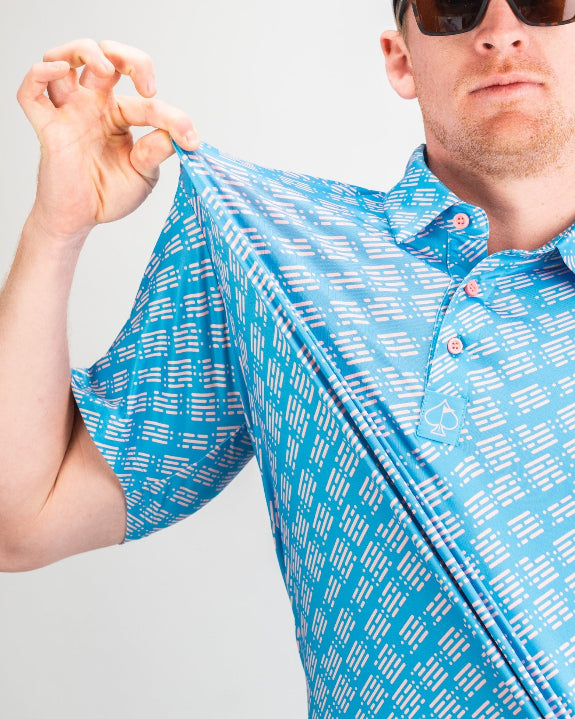 Men’s Skyline Dash Blue golf polo by Pins & Aces featuring a bright blue geometric dash pattern with pink accents and an athletic performance fit.