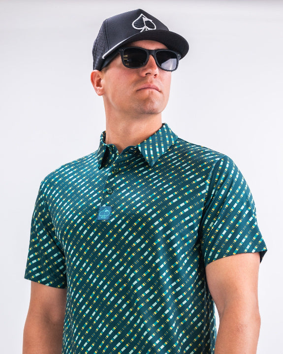 Men’s Chromo Green performance golf polo by Pins & Aces featuring an all-over green, blue, and yellow diagonal geometric stripe pattern with short sleeves and an athletic fit.