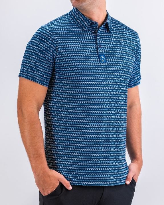 Men’s Rising Tides golf polo by Pins & Aces featuring a repeating blue and navy wave-inspired pattern, short sleeves, and an athletic performance fit.