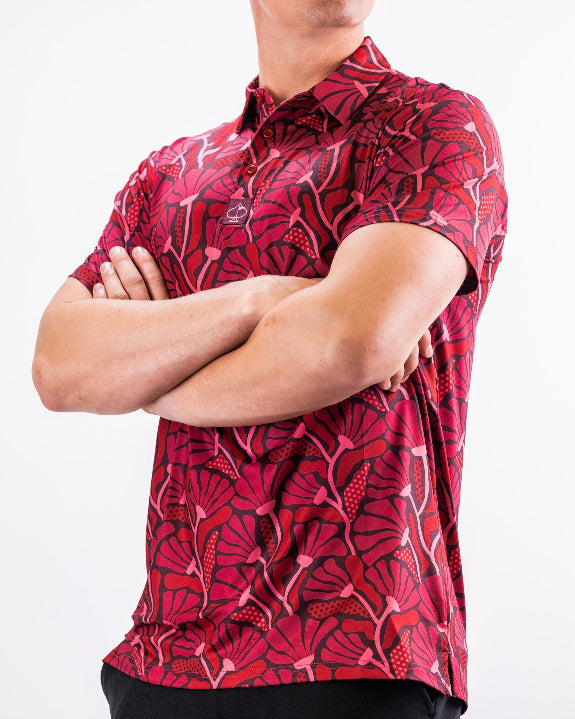 Men’s Garden Party Crimson Bloom golf polo by Pins & Aces featuring an oversized crimson, red, pink, and burgundy floral print with short sleeves and an athletic performance fit.