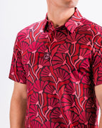 Men’s Garden Party Crimson Bloom golf polo by Pins & Aces featuring an oversized crimson, red, pink, and burgundy floral print with short sleeves and an athletic performance fit.