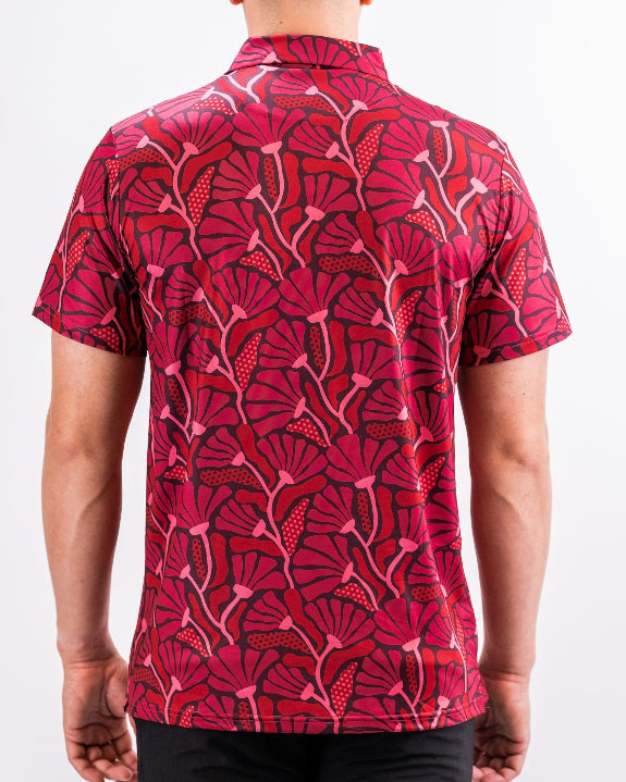 Men’s Garden Party Crimson Bloom golf polo by Pins & Aces featuring an oversized crimson, red, pink, and burgundy floral print with short sleeves and an athletic performance fit.