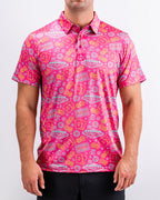 Men’s Big Ace Fuchsia golf polo by Pins & Aces featuring a bright pink casino print with playing cards, dice, poker chips, slot machines, and an athletic performance fit.