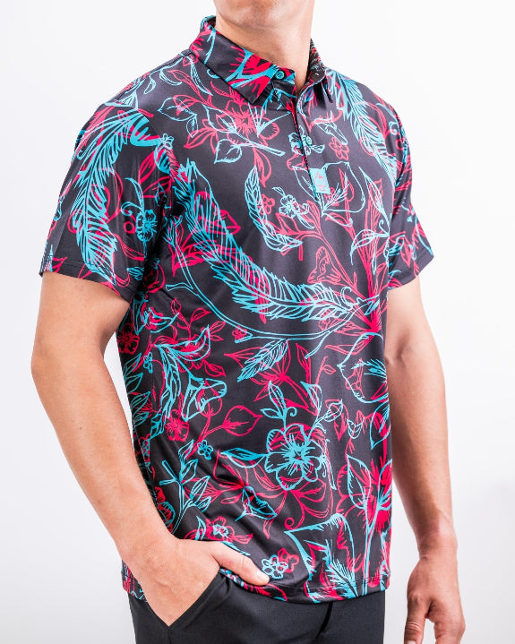 Men’s Cabo Electric golf polo by Pins & Aces featuring an aqua, hot pink, and coral tropical floral and leaf print on a dark charcoal background with an athletic performance fit.
