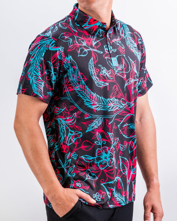 Men’s Cabo Electric golf polo by Pins & Aces featuring an aqua, hot pink, and coral tropical floral and leaf print on a dark charcoal background with an athletic performance fit.
