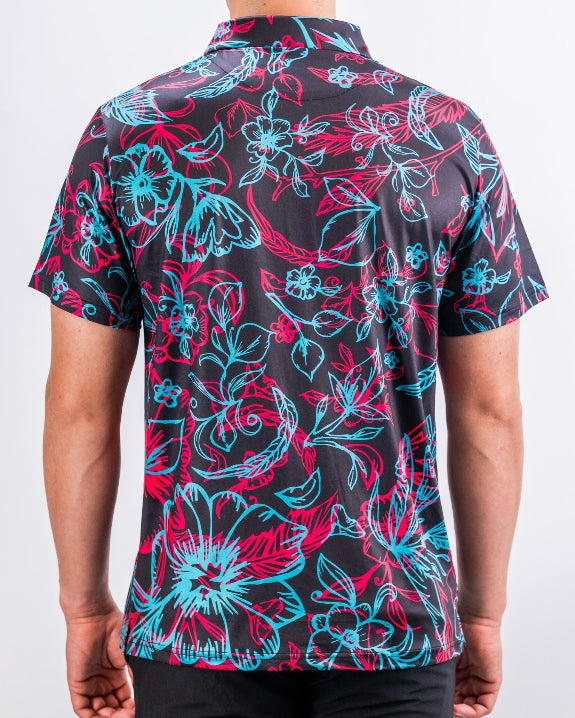 Men’s Cabo Electric golf polo by Pins & Aces featuring an aqua, hot pink, and coral tropical floral and leaf print on a dark charcoal background with an athletic performance fit.