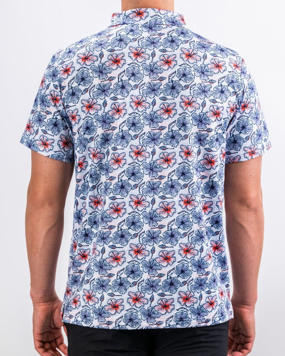 Men’s Hibiscus Harmony golf polo by Pins & Aces featuring blue and coral hibiscus flowers on a white lightweight performance golf shirt.