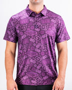 Men’s purple casino golf polo by Pins & Aces featuring an all-over pattern of playing cards, dice, poker chips, slot machines, and Las Vegas-inspired graphics.