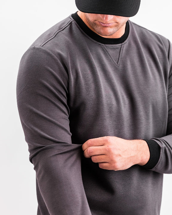 Men’s Player Preferred™ Slate Grey performance golf crewneck by Pins & Aces featuring a classic crew neckline, long sleeves, elastic cuffs and waist, and a tailored course-to-clubhouse fit.