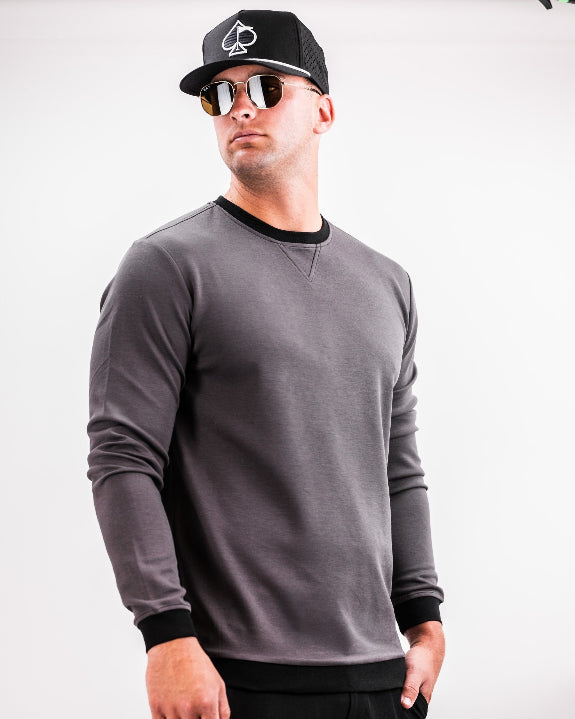 Men’s Player Preferred™ Slate Grey performance golf crewneck by Pins & Aces featuring a classic crew neckline, long sleeves, elastic cuffs and waist, and a tailored course-to-clubhouse fit.