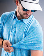 Men’s Margaritaville Rendezvous performance golf polo by Pins & Aces featuring a bright blue all-over pattern, short sleeves, collared neckline, and athletic fit.