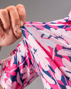 Men’s Brushed Flowers golf polo by Pins & Aces featuring a bold pink, blush, white, blue, and navy floral print with short sleeves and an athletic performance fit.