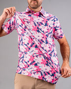 Men’s Brushed Flowers golf polo by Pins & Aces featuring a bold pink, blush, white, blue, and navy floral print with short sleeves and an athletic performance fit.