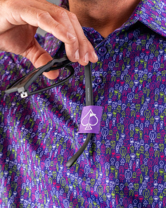 Men’s Doodle Guy Purple golf polo by Pins & Aces featuring an all-over purple, violet, blue, and green doodle-inspired pattern with short sleeves and an athletic performance fit.