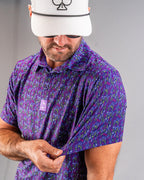Men’s Doodle Guy Purple golf polo by Pins & Aces featuring an all-over purple, violet, blue, and green doodle-inspired pattern with short sleeves and an athletic performance fit.