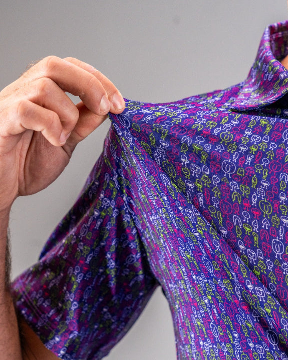 Men’s Doodle Guy Purple golf polo by Pins & Aces featuring an all-over purple, violet, blue, and green doodle-inspired pattern with short sleeves and an athletic performance fit.