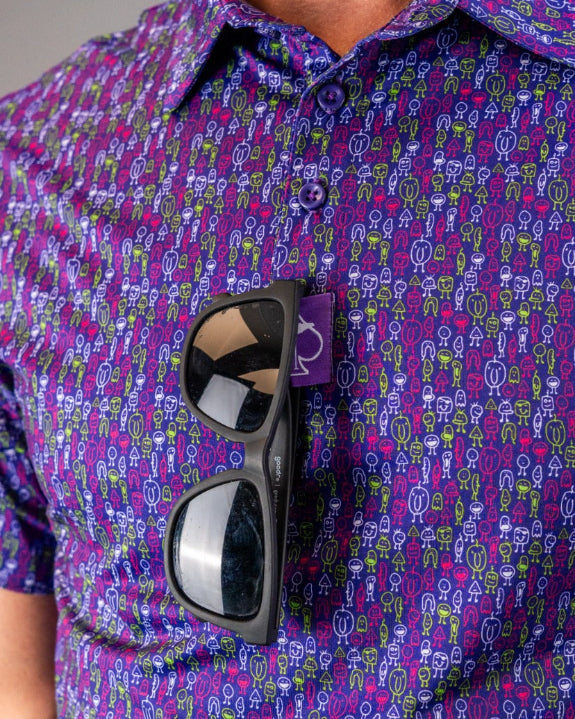 Men’s Doodle Guy Purple golf polo by Pins & Aces featuring an all-over purple, violet, blue, and green doodle-inspired pattern with short sleeves and an athletic performance fit.