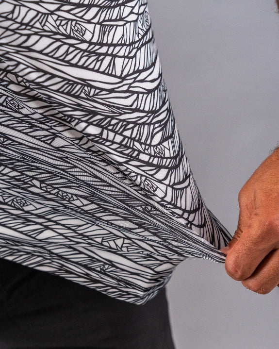 Men’s Fragment Black golf polo by Pins & Aces featuring an all-over black, white, and gray abstract line pattern with short sleeves and an athletic performance fit.