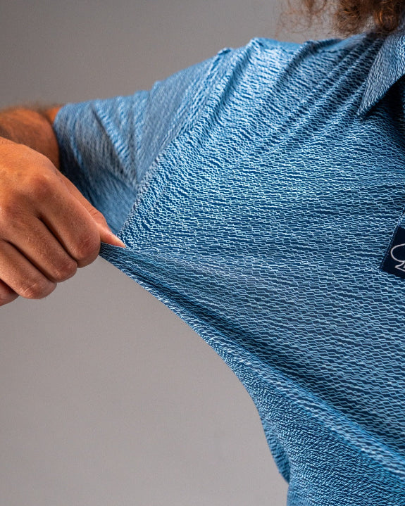 Men’s Squiggle Blue performance golf polo by Pins & Aces featuring a subtle textured blue pattern, short sleeves, and athletic fit.