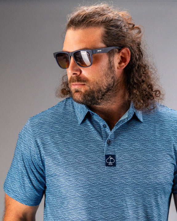 Men’s Squiggle Blue performance golf polo by Pins & Aces featuring a subtle textured blue pattern, short sleeves, and athletic fit.