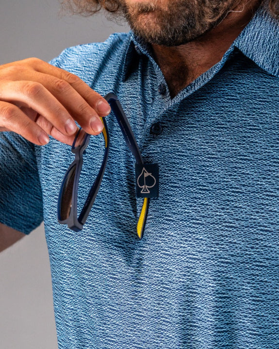 Men’s Squiggle Blue performance golf polo by Pins & Aces featuring a subtle textured blue pattern, short sleeves, and athletic fit.