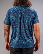 Men’s Swordfish Skelly golf polo by Pins & Aces featuring a blue, teal, and red ocean-inspired swordfish pattern with short sleeves and an athletic performance fit.