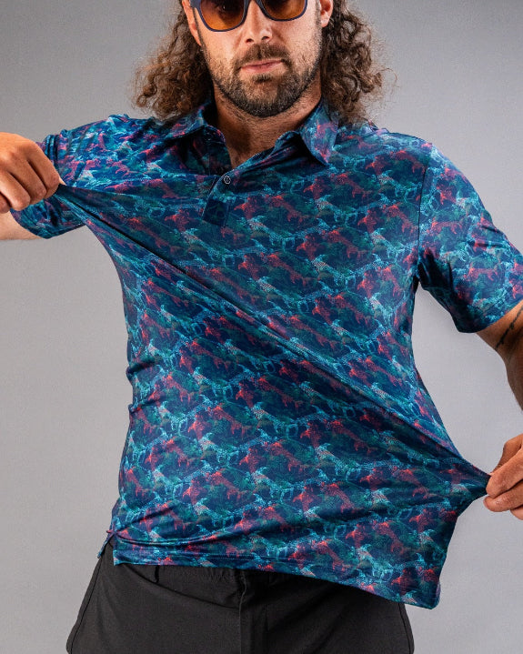 Men’s Swordfish Skelly golf polo by Pins & Aces featuring a blue, teal, and red ocean-inspired swordfish pattern with short sleeves and an athletic performance fit.
