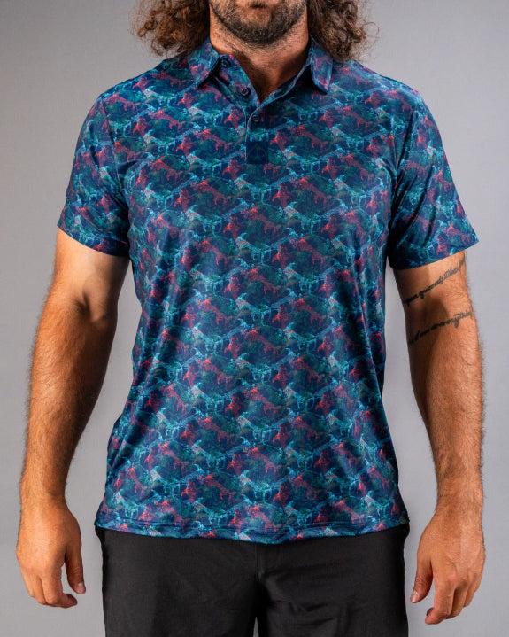 Men’s Swordfish Skelly golf polo by Pins & Aces featuring a blue, teal, and red ocean-inspired swordfish pattern with short sleeves and an athletic performance fit.