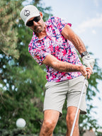 Men’s Brushed Flowers golf polo by Pins & Aces featuring a bold pink, blush, white, blue, and navy floral print with short sleeves and an athletic performance fit.