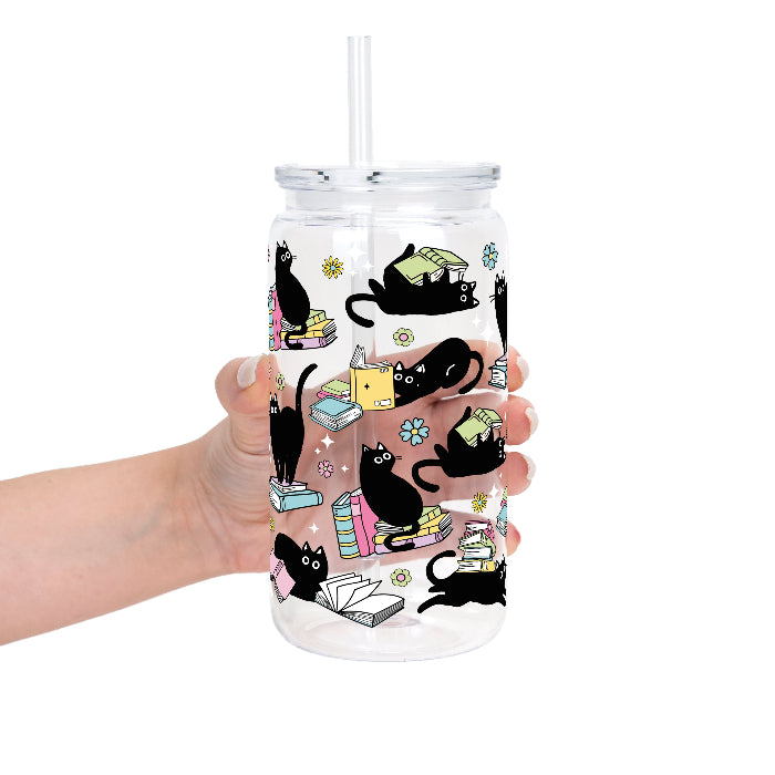 Black Cats on Books drinkware design featuring whimsical black cats lounging on colorful stacks of books with pastel flowers and bookish details.