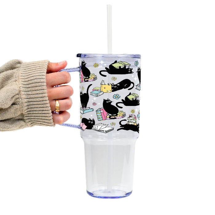 Black Cats on Books drinkware design featuring whimsical black cats lounging on colorful stacks of books with pastel flowers and bookish details.