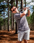 Men’s Jade Drops golf polo by Pins & Aces featuring a dark jade green geometric pattern, modern blade collar, short sleeves, and athletic performance fit.